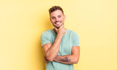 Genç, yakışıklı İspanyol adam gülümsüyor, hayattan zevk alıyor, mutlu, arkadaş canlısı, tatmin olmuş ve tasasız.