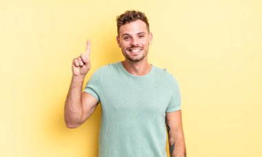 Genç, yakışıklı, İspanyol, neşeli ve mutlu bir şekilde gülümseyen bir adam.