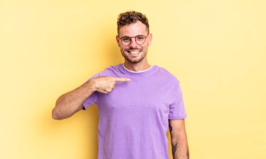 Genç, yakışıklı İspanyol adam mutlu, gururlu ve şaşırmış görünüyor, neşeli bir şekilde kendini gösteriyor, kendinden emin ve yüce hissediyor.