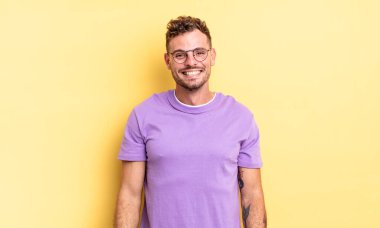 Genç, yakışıklı İspanyol adam mutlu ve şapşal görünüyor. Geniş, eğlenceli, deli gülüşü ve gözleri açık.