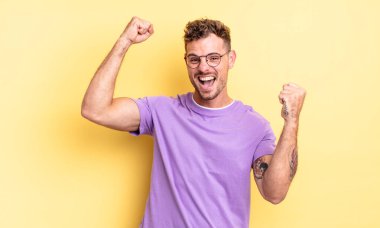 Genç, yakışıklı İspanyol adam zaferle bağırıyor. Heyecanlı, mutlu ve şaşırmış görünüyor. Kutlama yapıyor.