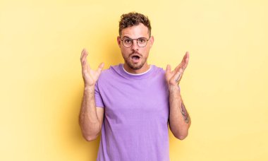 Genç, yakışıklı, İspanyol bir adam şok olmuş ve şaşkın görünüyor. İnanılmaz bir şey fark edince ağzı açık kaldı.