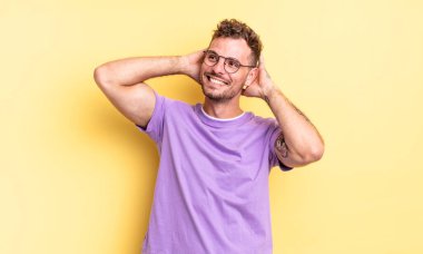 Genç, yakışıklı İspanyol adam gülümsüyor ve rahatlıyor, tatmin oluyor ve kaygısızca gülüyor.