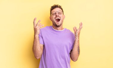 Genç, yakışıklı İspanyol adam öfkeyle bağırıyor, stresli ve elleri havada neden ben diye bağırıyor.