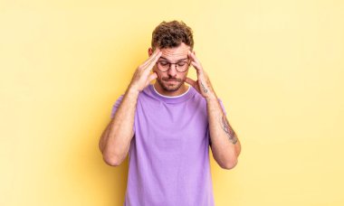 Genç, yakışıklı, İspanyol bir adam stresli ve hayal kırıklığına uğramış görünüyor. Baskı altında, baş ağrısı ve sorunlarıyla çalışıyor.