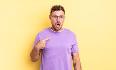 Genç, yakışıklı, şaşkın ve şaşkın bakan, ağzı açık, kendini işaret eden bir İspanyol.