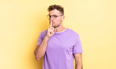 Genç, yakışıklı, İspanyol bir adam sessizlik ve sessizlik istiyor. Parmağını ağzının önüne uzatıp 
