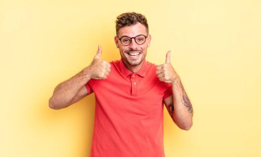 Genç, yakışıklı İspanyol adam gülümsüyor. Mutlu, pozitif, kendinden emin ve başarılı görünüyor.