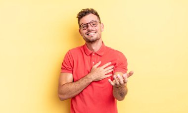 Genç, yakışıklı İspanyol bir adam mutlu ve aşık, bir eli kalbinin yanında gülümsüyor ve diğer eli önde uzanıyor.