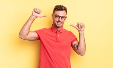 Genç, yakışıklı İspanyol adam gururlu, kibirli ve kendinden emin, tatmin olmuş ve başarılı görünüyor, kendini işaret ediyor.