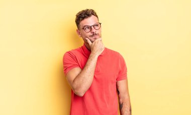 Genç, yakışıklı İspanyol adam düşünüyor, kuşkulu ve şaşkın hissediyor, farklı seçenekleri var, hangi kararı vereceğini merak ediyor.