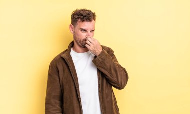 Genç, yakışıklı İspanyol bir adam iğreniyor. Pis ve nahoş bir koku duymamak için burnunu tutuyor.