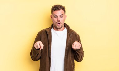 Genç, yakışıklı, İspanyol bir adam şok olmuş, ağzı açık ve şaşırmış hissediyor. İnançsızlık ve şaşkınlık içinde bakıyor ve onu işaret ediyor.