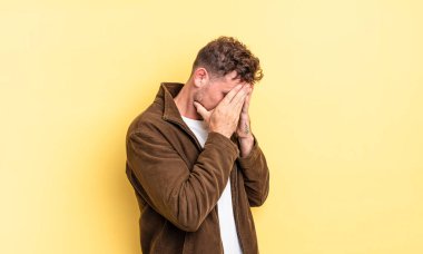 Genç, yakışıklı, İspanyol bir adam, üzgün, hayal kırıklığına uğramış bir bakışla gözlerini kapatıyor, ağlıyor, yan gözle bakıyor.