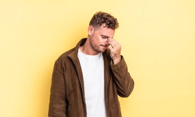 Genç, yakışıklı İspanyol bir adam stresli, mutsuz ve hayal kırıklığına uğramış, alınlı ve şiddetli baş ağrısı çeken.