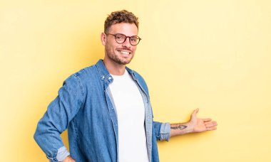 Genç, yakışıklı İspanyol adam kendini mutlu ve neşeli hissediyor, gülümsüyor ve seni hoş karşılıyor, seni dostça bir jestle içeri davet ediyor.