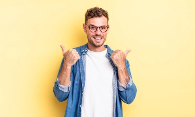 Genç, yakışıklı İspanyol adam neşeyle gülümsüyor ve mutlu görünüyor, kaygısız ve pozitif hissediyor.