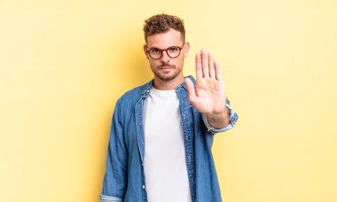 Genç, yakışıklı İspanyol adam ciddi, sert, hoşnutsuz ve kızgın görünüyor.