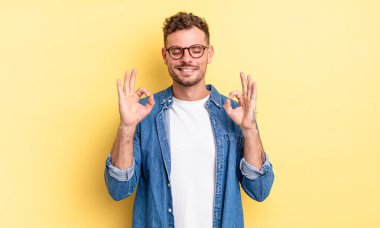 Genç ve yakışıklı İspanyol adam konsantre ve meditasyon yapıyor, kendini tatmin olmuş ve rahatlamış hissediyor, düşünüyor ya da bir seçim yapıyor.