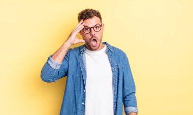 Genç yakışıklı İspanyol adam mutlu, şaşkın ve şaşırmış görünüyor, gülümsüyor ve inanılmaz ve inanılmaz iyi haberleri fark ediyor.