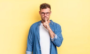 Genç, yakışıklı İspanyol adam ciddi görünüyor ve parmaklarını dudaklarına bastırıp sessizlik ya da sessizlik talep ediyor, sır saklıyor.