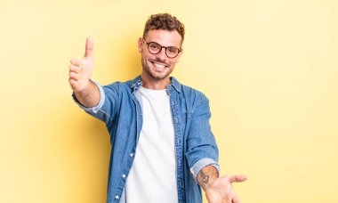 Genç, yakışıklı İspanyol adam neşeyle gülümsüyor sıcak, dostça, sevgi dolu bir kucaklama yapıyor, mutlu ve sevimli hissediyor.