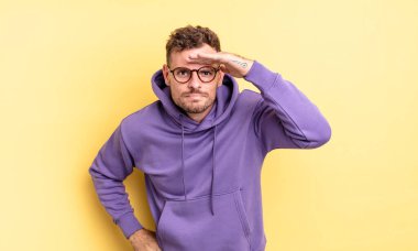 Genç, yakışıklı, İspanyol bir adam şaşkınlık ve şaşkınlık içinde bakıyor. Alnı açık, uzaklara bakıyor, izliyor ya da arıyor.