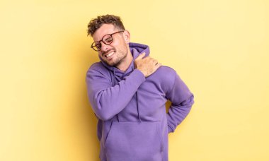 Genç yakışıklı İspanyol adam yorgun, stresli, endişeli, hayal kırıklığına uğramış ve depresyonda, sırtı ya da boynu ağrıyan