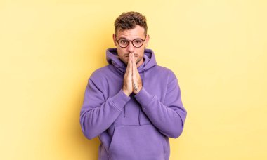 Genç, yakışıklı İspanyol adam endişeli, umut dolu ve dindar. Avuçlarına bastırılmış, af dilenen sadık bir şekilde dua ediyor.