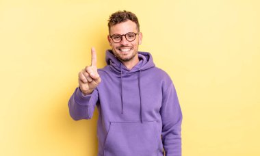 Genç, yakışıklı İspanyol adam gülümsüyor ve arkadaş canlısı görünüyor. Bir numara ya da ilk eli önde, geriye doğru sayıyor.