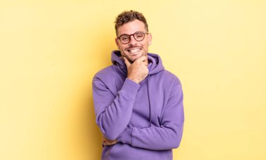 Genç, yakışıklı İspanyol adam gülümsüyor, hayattan zevk alıyor, mutlu, arkadaş canlısı, tatmin olmuş ve tasasız.