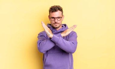 Genç, yakışıklı, İspanyol bir adam senin tavırlarından rahatsız ve bıkkın görünüyor. Yeter! Eller önde çapraz, durmanı söylüyor.