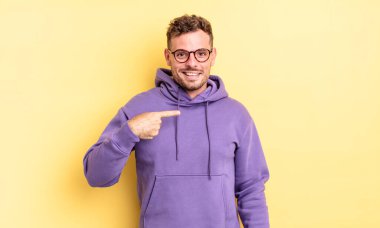 Genç, yakışıklı İspanyol adam mutlu, gururlu ve şaşırmış görünüyor, neşeli bir şekilde kendini gösteriyor, kendinden emin ve yüce hissediyor.