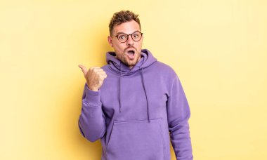 Genç, yakışıklı İspanyol adam, inançsızlıktan şaşkın şaşkın bakıyor, yan taraftaki objeyi işaret ediyor ve diyor ki: