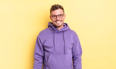 Genç, yakışıklı İspanyol adam mutlu ve şapşal görünüyor. Geniş, eğlenceli, deli gülüşü ve gözleri açık.