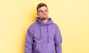 Genç, yakışıklı İspanyol bir adam kafası karışmış ve şaşkın görünüyor. Bir sorunu çözmeye çalışıyor ya da düşünüyor.