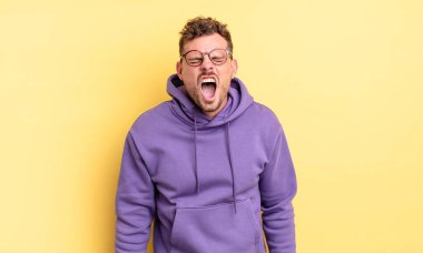 Genç, yakışıklı İspanyol adam agresif bir şekilde bağırıyor. Kızgın, sinirli, sinirli ya da sinirli görünüyor.