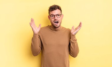 Genç, yakışıklı, İspanyol bir adam şok olmuş ve şaşkın görünüyor. İnanılmaz bir şey fark edince ağzı açık kaldı.
