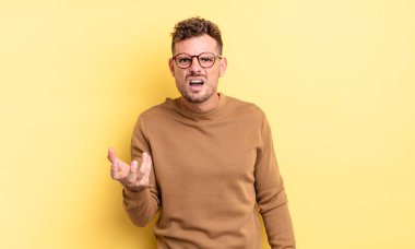 Genç, yakışıklı İspanyol bir adam sinirli, sinirli ve sinirli görünüyor. Senin neyin var? 