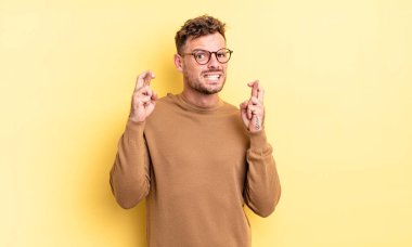 Genç yakışıklı İspanyol adam endişeyle dua ediyor ve endişeli bir bakışla iyi şanslar diliyor.