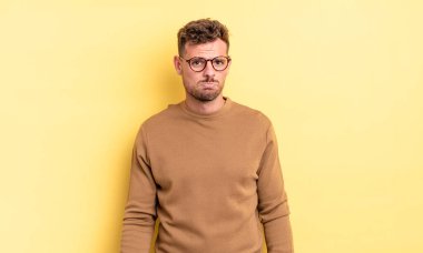 Genç, yakışıklı İspanyol bir adam üzgün ve mızmız, mutsuz bir bakışla, olumsuz ve hayal kırıklığına uğramış bir tavırla ağlıyor.