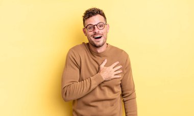 Genç, yakışıklı İspanyol bir adam şok olmuş ve şaşırmış hissediyor, gülümsüyor, el ele tutuşuyor, mutlu ya da şükran duyuyor.