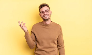 Genç, yakışıklı İspanyol bir adam mutlu, şaşırmış ve neşeli, pozitif bir tavırla gülümsüyor, bir çözüm ya da fikri fark ediyor.