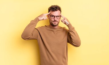 Ciddi ve konsantre görünümlü genç, yakışıklı İspanyol bir adam beyin fırtınası yapıyor ve zorlu bir sorunu düşünüyor.