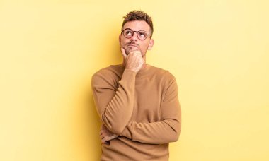 Genç, yakışıklı İspanyol adam düşünüyor, kuşkulu ve şaşkın hissediyor, farklı seçenekleri var, hangi kararı vereceğini merak ediyor.