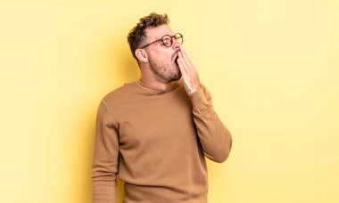 Genç yakışıklı İspanyol adam sabahın erken saatlerinde uyanıyor ve uykulu, yorgun ve sıkılmış görünüyor.