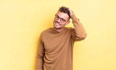 Genç, yakışıklı İspanyol adam neşeli ve sıradan bir şekilde gülümsüyor. Olumlu, mutlu ve kendinden emin bir bakışla yumruk yumruğa.