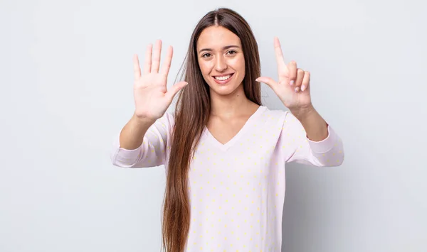 ヒスパニック系のかなり女性は笑顔と友好的に見える 前方に手で数字7または7番目を示し カウントダウン — ストック写真