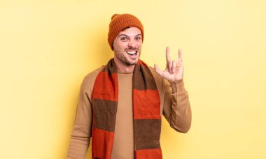 Genç, yakışıklı İspanyol adam kendini mutlu, eğlenceli, kendinden emin, pozitif ve asi hissederek elle rock veya heavy metal işareti yapıyor.