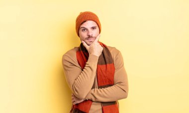 Genç, yakışıklı İspanyol bir adam ciddi, düşünceli ve güvensiz görünüyor, bir kolu çapraz ve çenesi üzerinde, seçenekleri tartıyor.